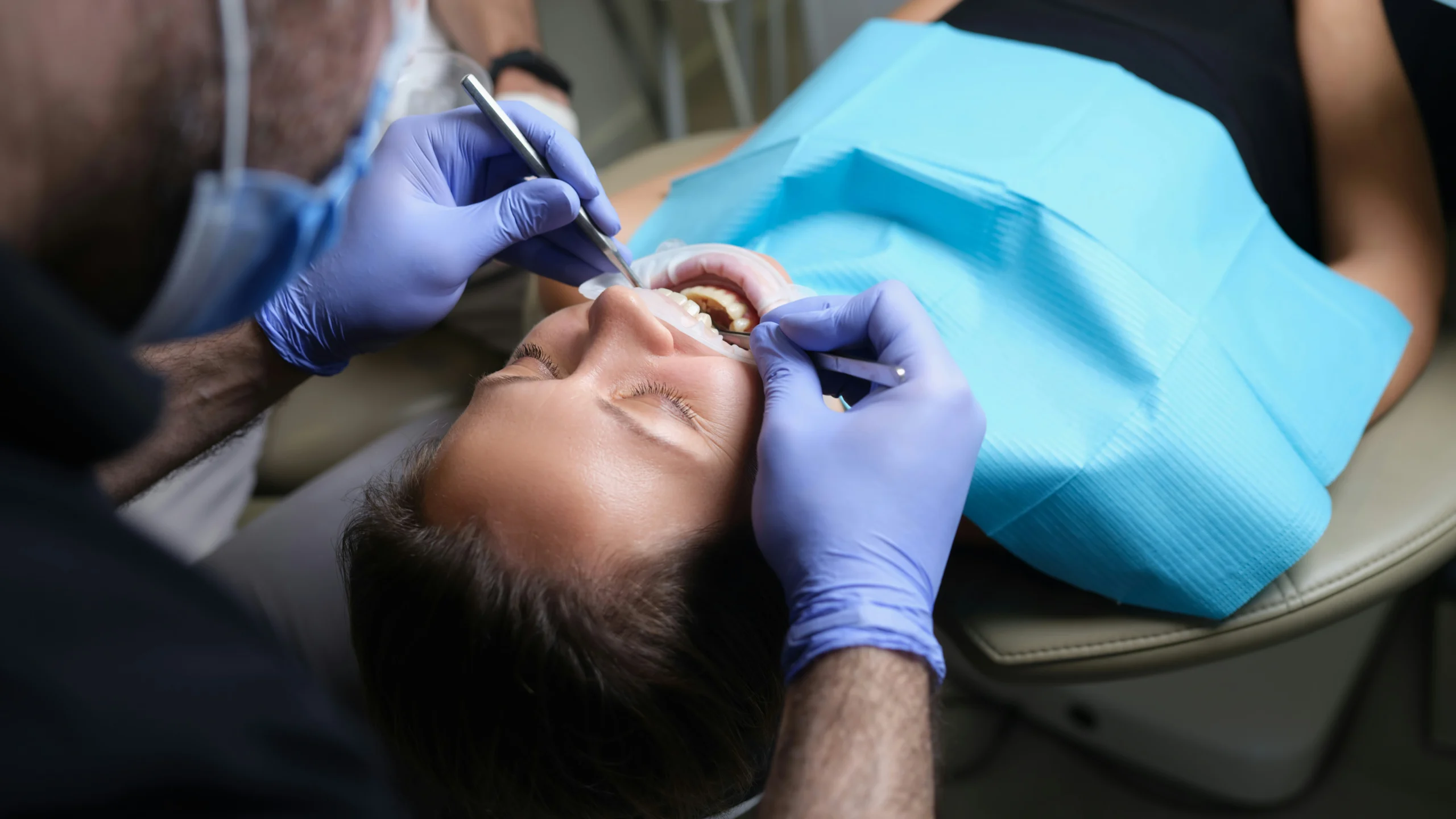 profesional implantando a un paciente coronas y puentes dentales